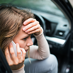 woman in car distressed on phone